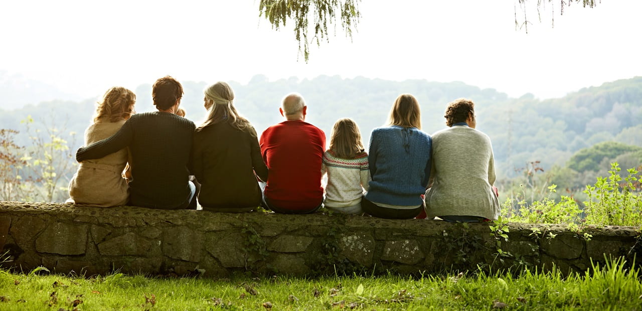 Multi-generation family relaxing on retaining wall